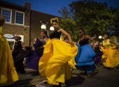 A group of dancers in bright yellow and blue skirts
