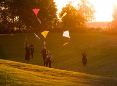 Image of a group of people flying kites.