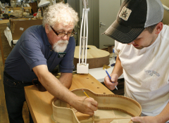 Two artists working on building a guitar.