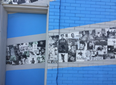 Bright blue mural with black and white photos along the wall