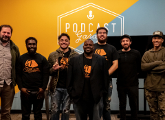 A group of young men standing in a row at a work showcase at the PRX Podcast Garage.