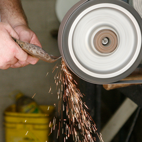 Image of a tool being sharpened and sparks flying