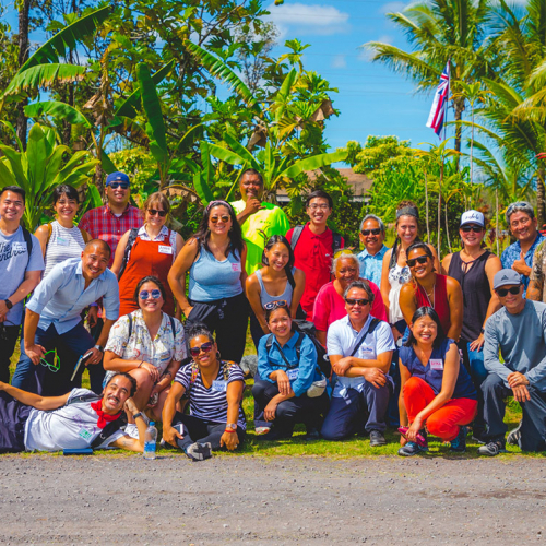 Two dozen people posing for a group photo in Hawai'i