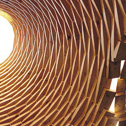 A series of wooden planks create a dome with an opening for light at the top