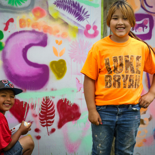 Two young kids, one with a spray can, at RedCan Jam 2019