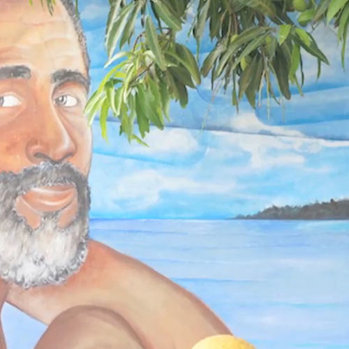 Mural of a Puerto Rican man with the blue skies and ocean behind him