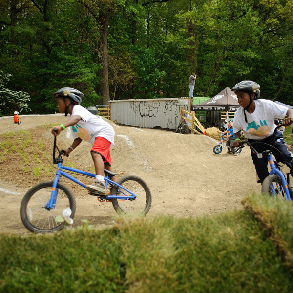 Two black kids on bicycles having fun on a dirt trail