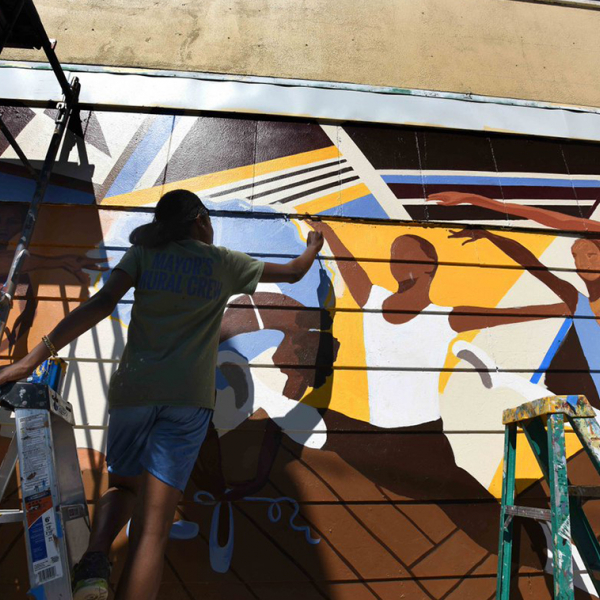 Image of an artists painting a wall mural.