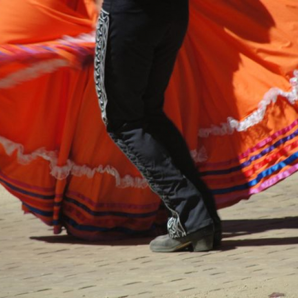 Photo of the legs of a man and woman dancing ballet folklorico in traditional wear
