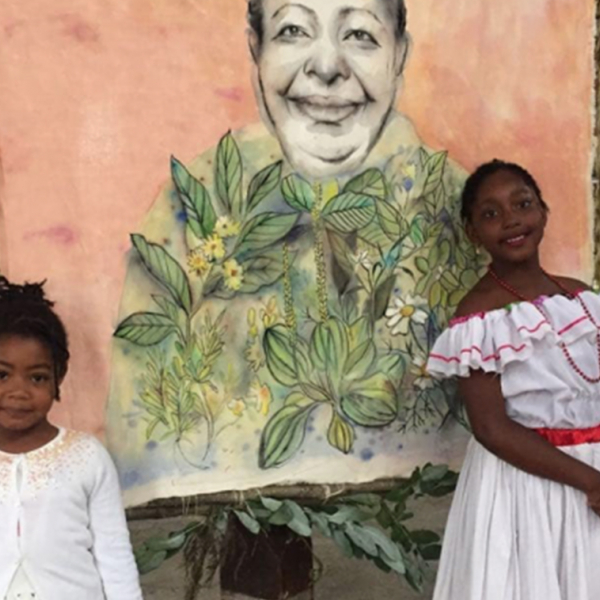 Two young black girls standing in front of a painting