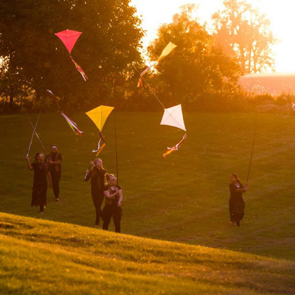 Image of a group of people flying kites.