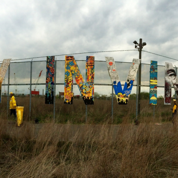 Art installation featuring letters on a chain-link fence