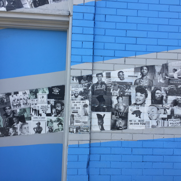 Bright blue mural with black and white photos along the wall