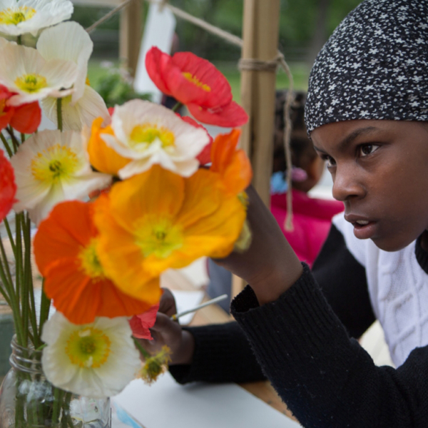 A young black girl working on paper flowers